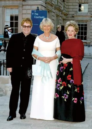 En 2002, rodeada por Camilla Parker-Bowles y Elton John en un evento de recaudación de fondos en ayuda de Ark (Absolute Return for Kids) en Somerset House, Londres.