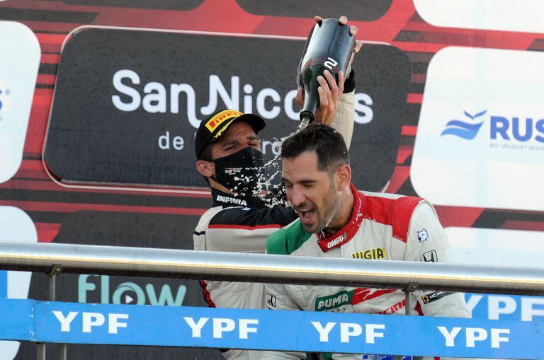 Matías Rossi, el campeón defensor y actual puntero del campeonato de Súper TC2000, baña con champagne a Facundo Ardusso, ganador en San Nicolás; el parejense sumó su decimocuarta victoria en la categoría, la segunda con Honda