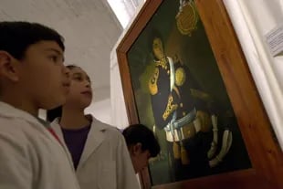 Los niños observan la pintura de general en una muestra en honor a José de San Martín