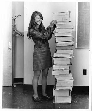 Margarte Hamilton en 1969, parada junto a la transcripción en papel de código fuente del software de las computadoras del Apollo 11