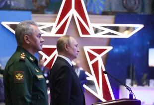 El presidente ruso Vladimir Putin y el ministro de Defensa Sergei Shoigu recorren una exhibición de equipo militar antes de la reunión anual de la junta del Ministerio de Defensa en Moscú el 21 de diciembre de 2021.