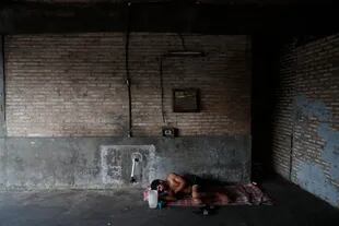 Un trabajador duerme en el piso de un almacén en el "Mercado de Abasto", donde está varado después de que los autobuses dejaran de funcionar durante la cuarentena en Asunción