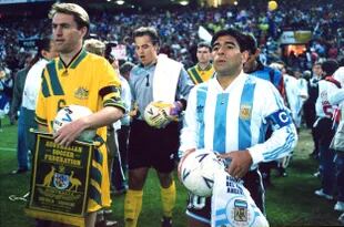 El capitán argentino Diego Maradona entra a la cancha junto al capitán australiano Paul Wade