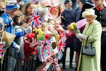 La reina Isabel II de Gran Bretaña recoge flores y buenos deseos durante una caminata para celebrar su 90 cumpleaños en Windsor, Inglaterra, el jueves 21 de abril de 2016