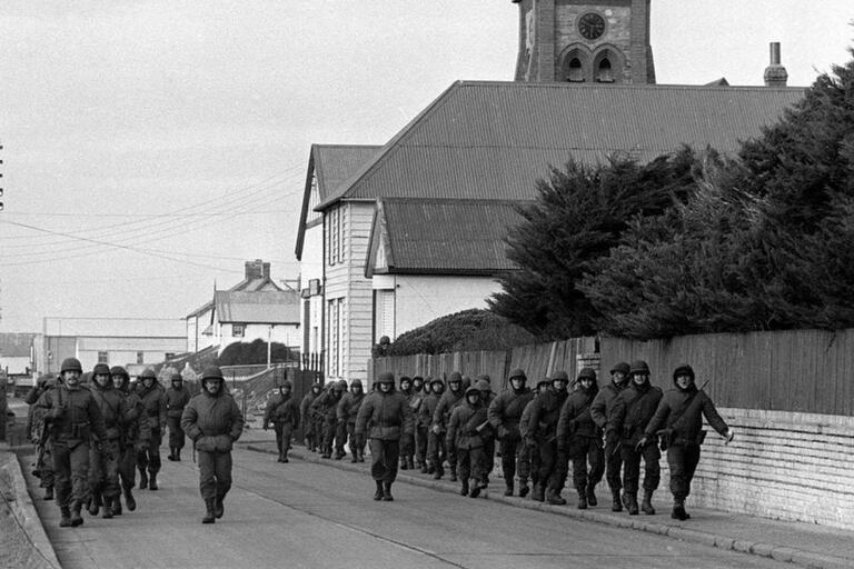 Soldados argentinos caminan por la Avenida Ross, luego de la toma de las islas Malvinas, en abril de 1982
