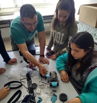 Alumnas de nivel básico trabajando con un profesor para armar robots y drones