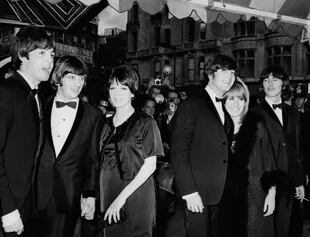 Cynthia vivió los primeros años de éxito de The Beatles. En la imagen, de izquierda a derecha: Paul McCartney, Ringo Starr con su mujer Maureen, John Lennon y Cynthia Powell, y George Harrison. La fotografía fue tomada durante la premiere del fil "Help", en de julio de 1965 (Photo by Daily Express/Archive Photos/Getty Images).