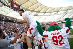 Atakan Karazor, del Stuttgart, festeja con fans luego del triunfo 2-1 contra Colonia que le permitió a Stuttgart salvarse del descenso en la última fecha de la Bundesliga, sábado 14 de mayo de 2022. (Tom Weller/dpa via AP)