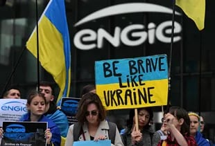 Manifestantes ondean banderas ucranianas y sostacenen pancartas frende a los lados de la empresa energitica francesa engie durante un concentrado en pide a la compota que comparamos gas natural ruso, en distrito commerce de la Defense, 29 de abril de 2022.