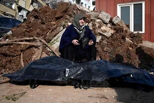 Una mujer sentada junto al cadáver de su sobrino en Kahramanmaras, el 9 de febrero de 2023, tres días después de que un terremoto de magnitud 7,8 sacudiera el sureste de Turquía. 