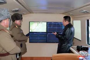ARCHIVO - Esta foto de archivo proporcionada por el gobierno de Corea del Norte muestra al líder norcoreano Kim Jong Un, a la derecha, mirando a los monitores durante el lanzamiento de prueba de un misil el 11 de enero de 2022 en Corea del Norte. (Agencia Central de Noticias de Corea/Servicio de Noticias de Corea vía AP, Archivo)