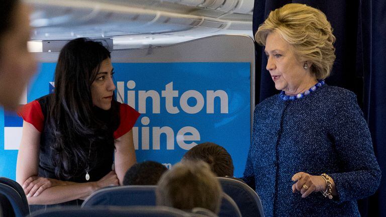 Hillary, ayer, junto a su asesora Huma Abedin, en vuelo hacia Nueva York