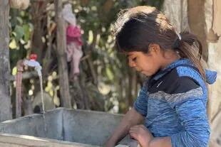 Analía (9 años) se pone a lavar un trapo en la canilla que da al canal: "cuando sea grande quiero trabajar de lavar la ropa", dice