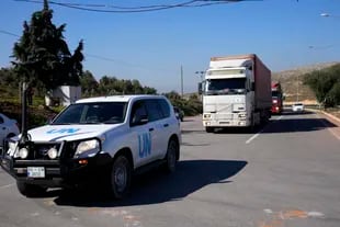 Camiones con ayuda para Siria siguen a un vehículo de la ONU en el paso fronterizo turco de Cilvegozu, en Reyhanli, sureste de Turquía, jueves 9 de febrero de 2023.
