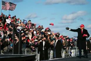 El presidente Donald Trump reparte gorritas en su llegada al aeropuerto Wilkes-Barre Scranton, Pensilvania, para el cierre de su campaña