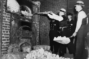 Agentes de la Oficina Federal de Estupefacientes de Estados Unidos introducen en una incineradora bloques de heroína confiscados en 1936