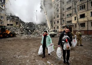 I residenti portano i loro averi da un condominio distrutto dopo un attacco missilistico, a Dnipro il 15 gennaio 2023, durante l'invasione russa dell'Ucraina.