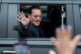 El actor Johnny Depp saluda a sus seguidores al salir del Tribunal del Condado de Fairfax