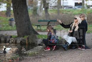 Durante el paseo por el parque, madre e hijas les dieron de comer a los patos. 