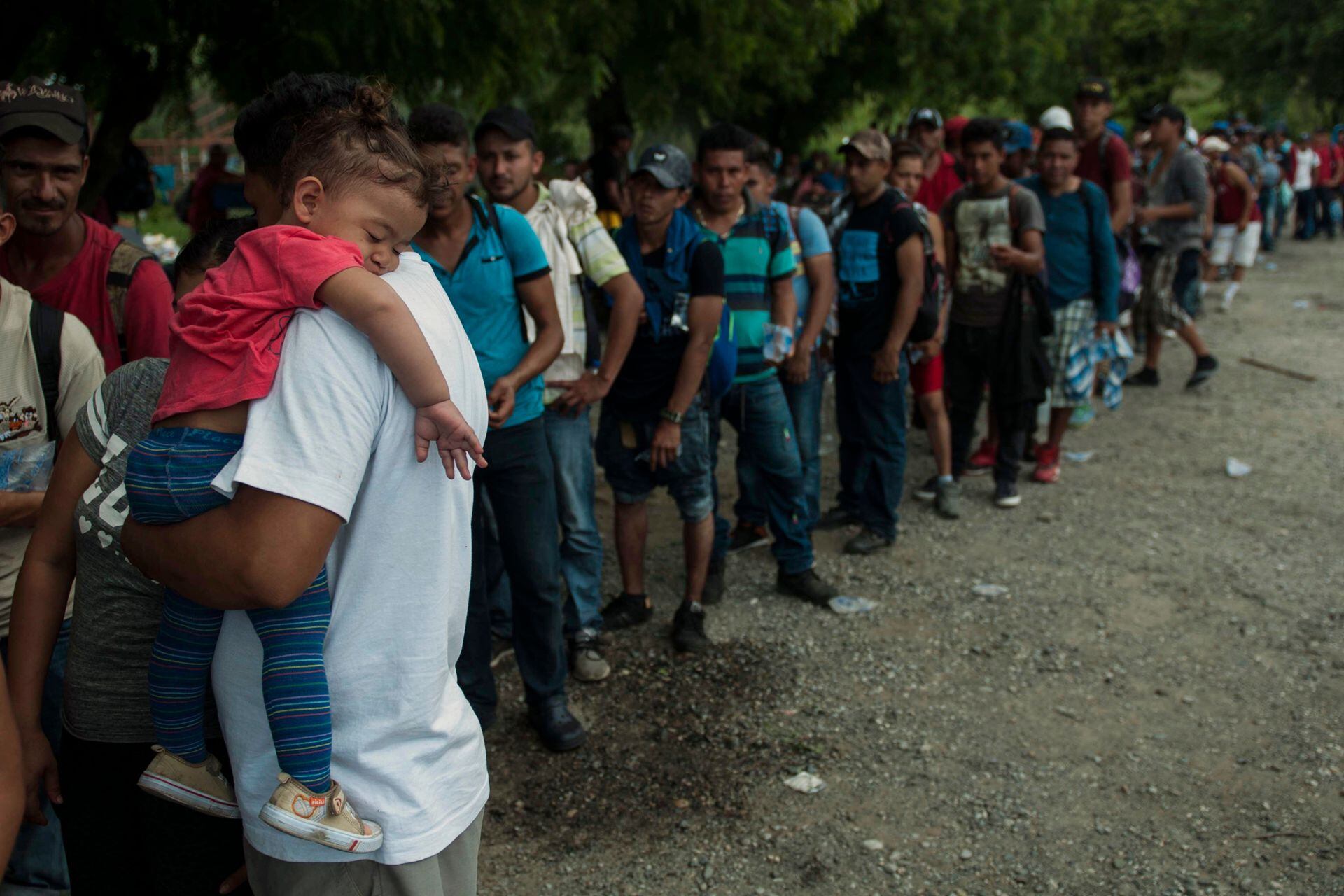  Los migrantes hondureños forman una fila para recibir alimentos donados