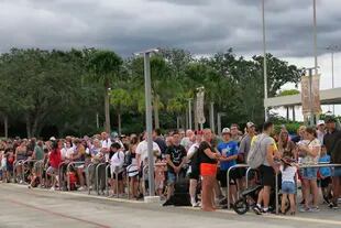 Turistas esperan para salir de Magic Kingdom, en Walt Disney World, después de que anunciaran el cierre de los parques