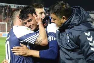 Los jugadores de Gimnasia abrazan a Oscar Piris tras la victoria ante Unión, en Santa Fe; el futbolista tripero rompió en llanto al recordar a su madre, fallecida en los últimos días