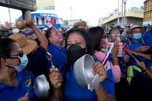 Mujeres golpean cacerolas mientras miembros del sindicato de maestros en huelga protestan durante una marcha hacia la Asamblea Nacional en Ciudad de Panamá, el lunes 11 de julio de 2022
