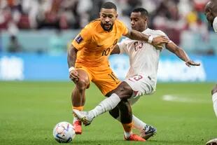 El neerlandés Memphis Depay recibe la presión en la marca del qatarí Assim Madibo durante el partido entre Países Bajos y Qatar
