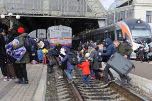 Gente que se apresta a salir de Ucrania desde la estación de Lviv