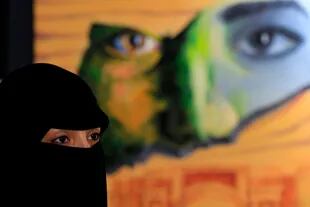 A Yemeni woman visits an art exhibition against war by Yemeni painters at the Peoples Development Foundation in the Yemeni capital of Sanaa on October 1, 2018. - About 24 Yemeni artists participated with more than 100 pieces of art work in an exhibition in Sanaa to attract attention to the ongoing w
