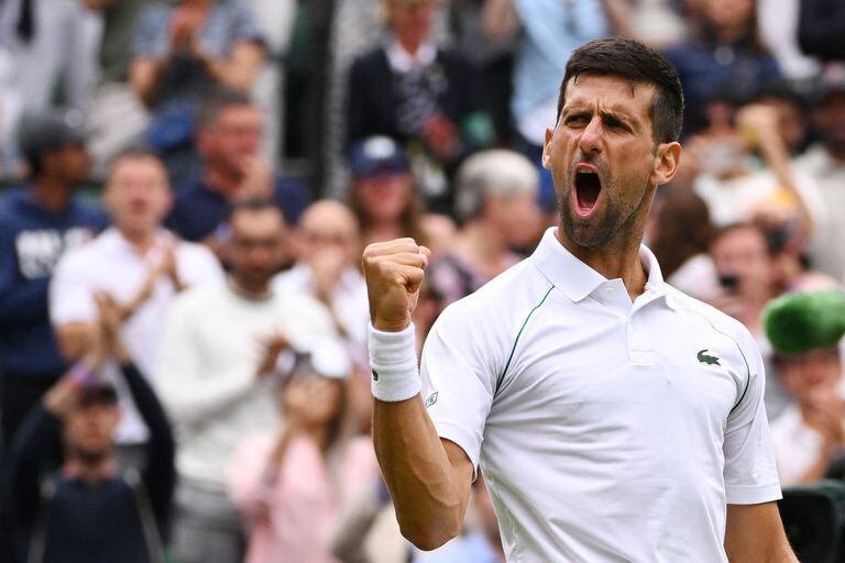 TOPSHOT - Serbia's Novak Djokovic celebrates winning against Italy's Jannik Sinner during their men's singles quarter final tennis match on the ninth day of the 2022 Wimbledon Championships at The All England Tennis Club in Wimbledon, southwest London, on July 5, 2022. (Photo by SEBASTIEN BOZON / AFP) / RESTRICTED TO EDITORIAL USE