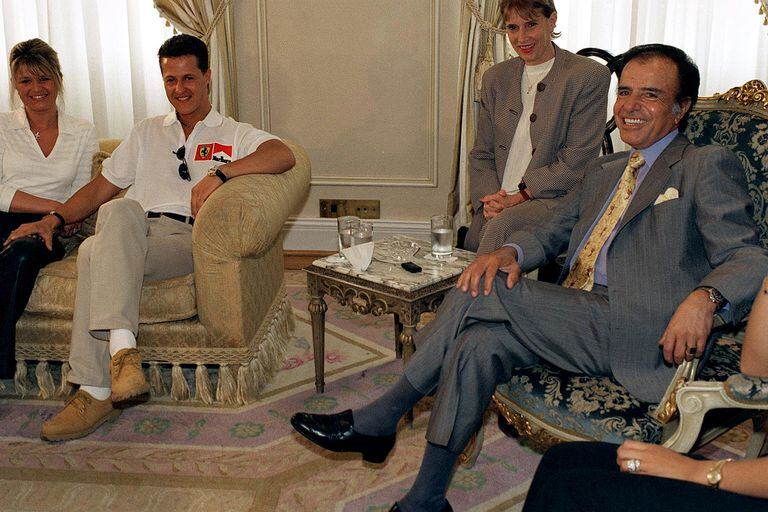 Carlos Menem y su tradicional joya junto al piloto de Fórmula 1, Michael Schumacher, en abril de 1997