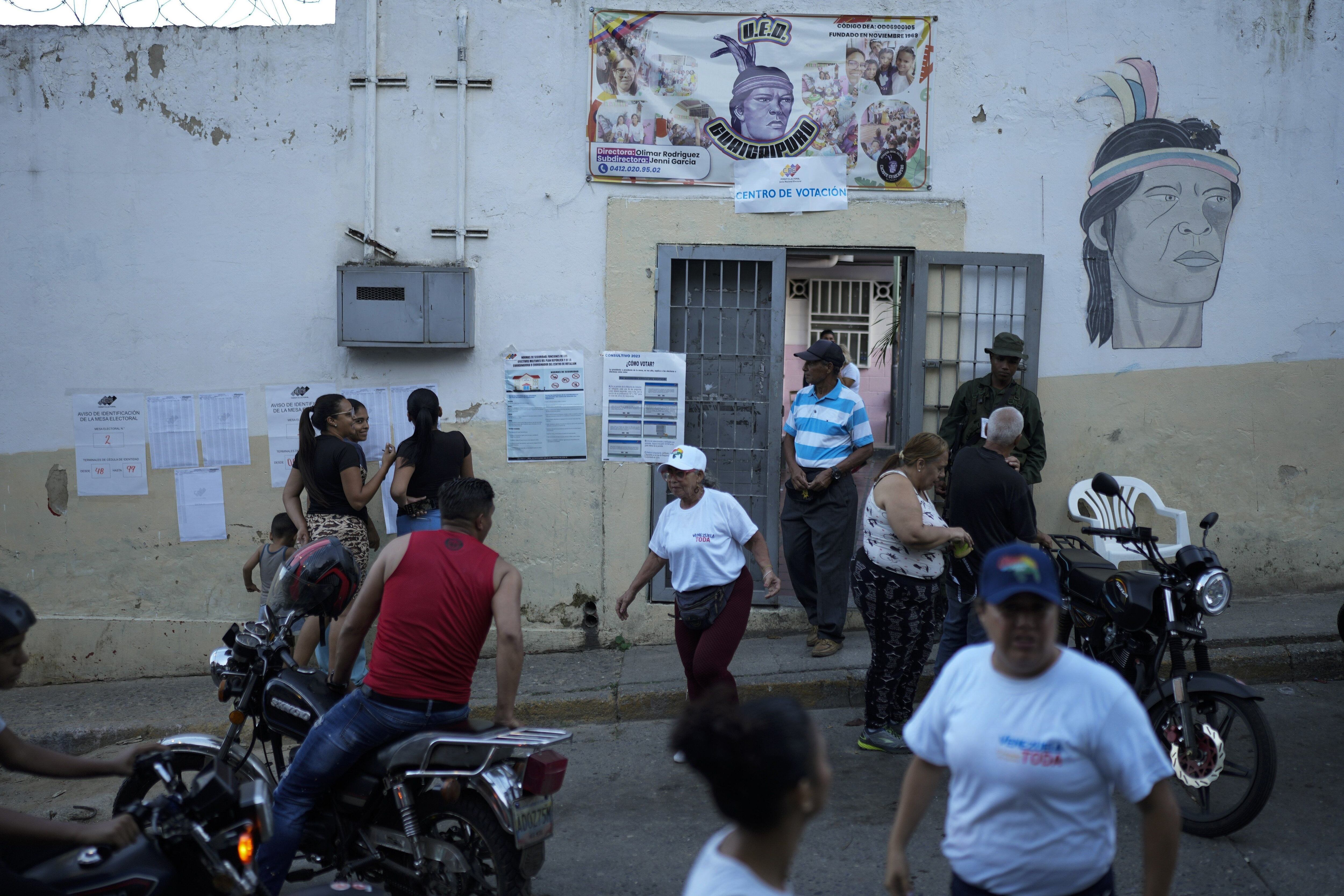 La gente se encuentra afuera de un colegio electoral durante un referéndum sobre el futuro del Esequibo, un territorio en disputa con Guyana, en un colegio electoral en Caracas, Venezuela, el domingo 3 de diciembre de 2023.