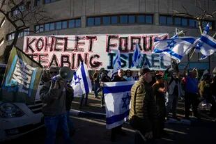 Manifestantes ondean banderas en una protesta contra el plan de reforma judicial del nuevo gobierno del primer ministro, Benjamin Netanyahu
