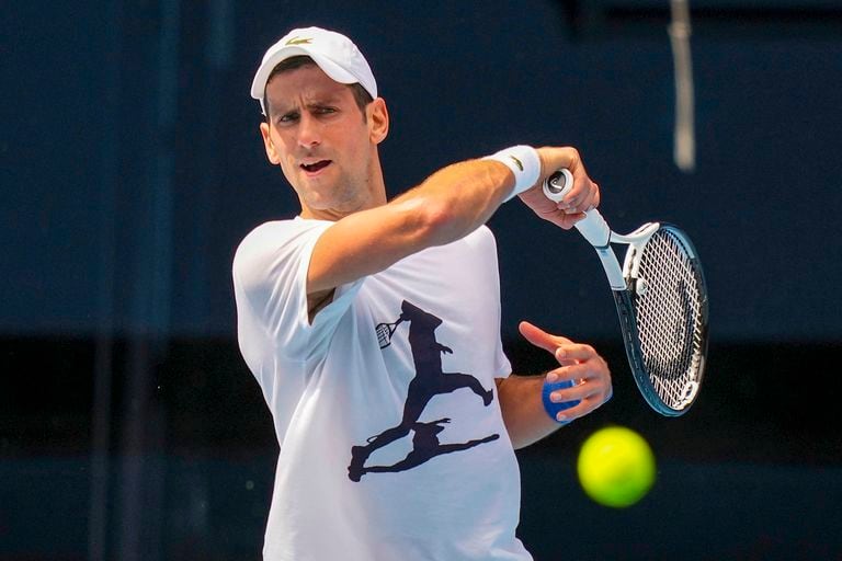 En esta foro proporcionada por Tennis Australia, el actual campeón del Abierto de Australia, el serbio Novak Djokovic, entrena en la cancha Rod Laver antes del Abierto de Australia en Melbourne Park, Australia, el martes