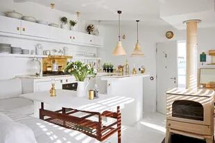 En su pequeñez, la cocina tiene el toque espléndido de una breve mesada de mármol de Carrara, y bacha en diagonal con grifería de bronce.