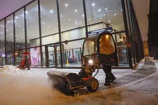 A man uses a snow blower to clear a sidewalk outside Union Station in Chicago, Illinois, on Dec. 22, 2022, during a winter storm ahead of the Christmas holiday.
