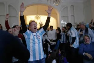 I tifosi festeggiano il secondo gol dell'Argentina mentre guardano la partita finale della Coppa del Mondo FIFA 2022 in Qatar tra Argentina e Francia sullo schermo dell'Ambasciata argentina a Parigi, 18 dicembre 2022.