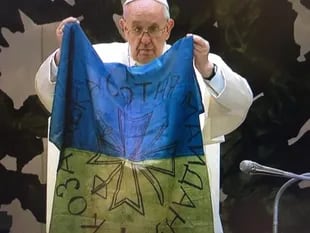 The Pope explains and kisses a flag that has just arrived from Bucha (Ukraine) at this Wednesday's general audience  