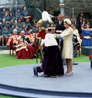 En esta foto de archivo del 1 de julio de 1969, el Príncipe Carlos se arrodilla ante su madre, la Reina Eizabeth II de Gran Bretaña, durante la ceremonia de investidura del Príncipe de Gales, en el Castillo de Caernafon en Gales.