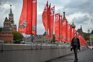 Una mujer pasa junto a pancartas rojas dedicadas al Día de la Victoria en el centro de Moscú el 6 de mayo de 2020