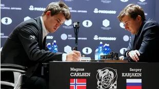 Carlsen toma nota; Karjakin observa el tablero. El campeón y el retador no se sacaron ventajas aún