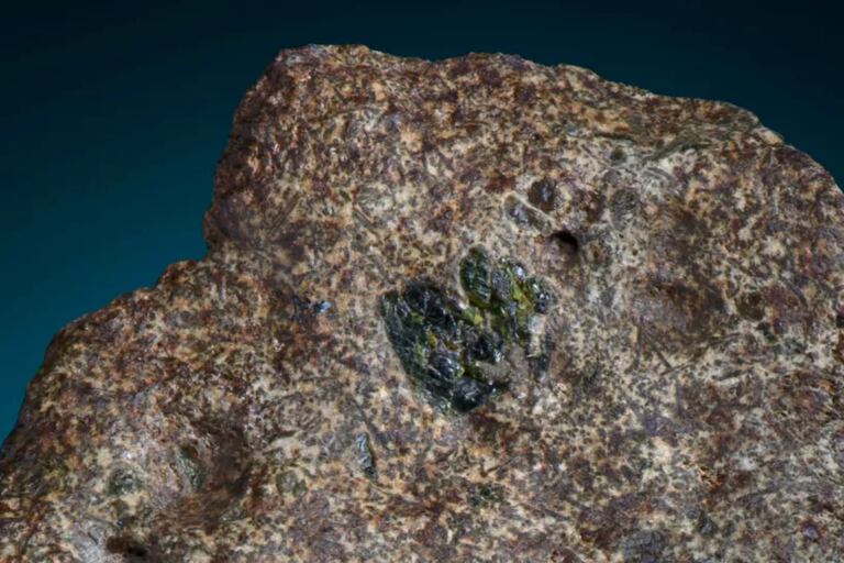 El meteorito EC 002 es "de grano relativamente grueso, bronceado y beige", con cristales de color verde, amarillo verdoso y amarillo marrón