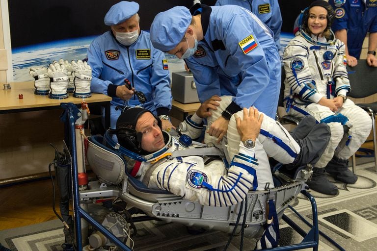 Miembros del staff espacial ruso ayudan a Yulia Peresild y a Klim Shipenko en una práctica previa al lanzamiento