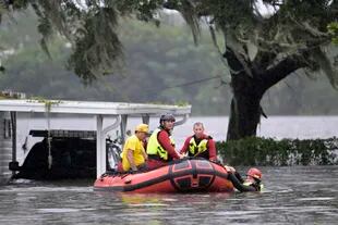 Personal de emergencias del equipo de bomberos del condado de Orange usan un bote inflable para rescatar a una persona de su residencia tras el paso del huracán Ian, el jueves 29 de septiembre de 2022, en Orlando, Florida. (AP Foto/Phelan M. Ebenhack)