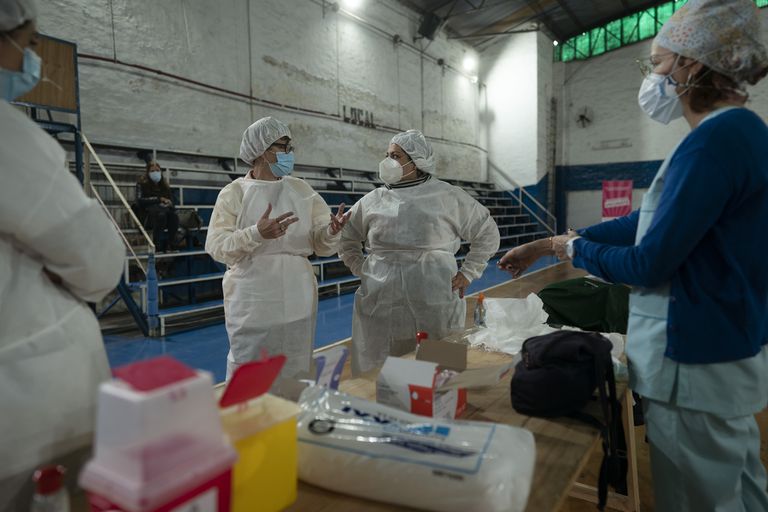 La supervisora ​​de enfermería Paola Almirón, centro derecha, organiza una campaña de vacunación contra el COVID-19 en un gimnasio en las afueras de Buenos Aires, Argentina, el viernes 9 de julio de 2021.  (AP Foto/Víctor R. Caivano)