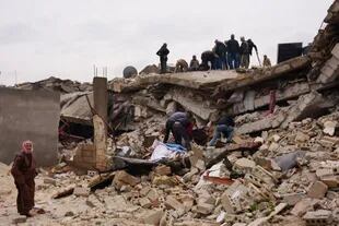 Residentes buscan entre los escombros de un edificio derrumbado tras un terremoto en la localidad de Jandaris, en el campo de la ciudad noroccidental siria de Afrin, en la parte de la provincia de Alepo controlada por los rebeldes, el 6 de febrero de 2023.