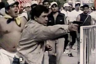 Miguel "Madonna" Quiroz dispara un arma durante los incidentes en el traslado de los restos de Perón a San Vicente, en el año 2006