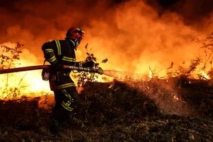 A firefighter battles a forest fire near Lucchats in Gironde, southwestern France, on July 17, 2022. 