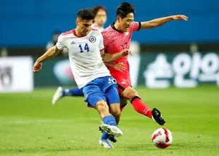 Pablo Galdames y Na Sang-ho luchan por el balón durante el partido entre Corea del Sur y Chile.